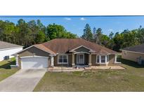 Charming one-story home featuring an attached two-car garage, well-kept lawn, and inviting curb appeal at 13361 Sw 88Th Ter, Ocala, FL 34473