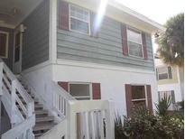 Charming exterior showcasing a two-story building with white stairs and red shutters at 8142 Fairways Cir # S204, Ocala, FL 34472