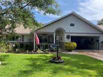 Charming home featuring a well-manicured lawn, stone accents, and an inviting front porch at 8533 Sw 93Rd Pl # A, Ocala, FL 34481