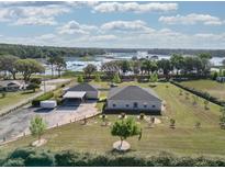 Beautiful aerial view of the property with lush landscaping and a picturesque lake in the background at 11395 Se 108Th Terrace Rd, Belleview, FL 34420