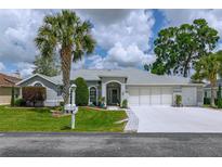 Charming single-story home with well-maintained landscaping, a three-car garage, and inviting curb appeal at 5195 Nw 21St Loop, Ocala, FL 34482