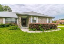Charming brick home with well-maintained lawn, decorative shutters, and welcoming front entrance at 828 Ne 51St Ave, Ocala, FL 34470