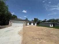 New home with a two-car garage, stone accents, and a spacious front yard ready for landscaping at 11537 Sw 59Th Ter, Ocala, FL 34476