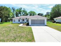 Charming single-story home featuring a screened two-car garage and a well-maintained front yard at 4998 Nw 30Th Pl, Ocala, FL 34482