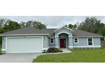 Charming single-story home with a well-manicured lawn and a two-car garage at 12864 Sw 40 Ter, Ocala, FL 34473