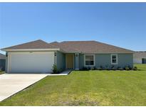 Charming single-story home with a well-manicured lawn and an attached two-car garage at 3474 Sw 155Th Pl, Ocala, FL 34473