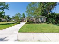 Charming single-story home with a well-maintained lawn and complemented by lush landscaping at 1103 Se 46Th St, Ocala, FL 34480