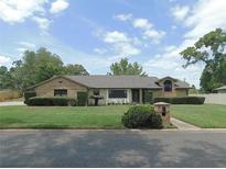Charming single-story home with brick accents, manicured lawn, and mature landscaping under a bright sky at 2865 Se 37Th St, Ocala, FL 34471