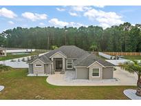 Stunning gray home with a well-manicured lawn and a spacious driveway, plus a fenced backyard with a pool at 6292 Se 13Th St, Ocala, FL 34472