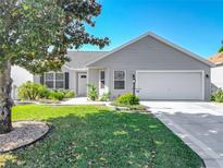 Charming single-story home featuring well-maintained landscaping, light-gray siding, and an attached two-car garage at 7474 Se 172Nd Fieldcrest St, The Villages, FL 32162