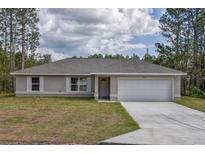 Charming one-story home features a two-car garage, well-manicured lawn, and classic architectural details at 861 Sw Fig Tree Ln, Dunnellon, FL 34431