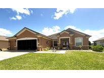 Charming single-story home featuring a stucco exterior, well-maintained lawn, and attached two-car garage at 13111 Se 86Th Cir, Summerfield, FL 34491