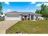 Charming single-story home with a well-manicured lawn and attached garage, perfect for suburban living at 27 Juniper Dr, Ocala, FL 34480