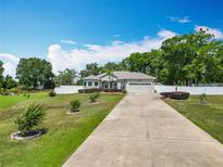 Charming single-story home with a well-maintained lawn, mature trees, and a long private driveway at 4033 Ne 15Th Court Rd, Ocala, FL 34479