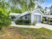 Charming single-story home featuring mature landscaping, a screened-in garage, and a welcoming front entrance at 8051 Sw 115 Loop, Ocala, FL 34481