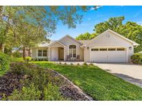 Charming single-story home with a well-manicured lawn and inviting curb appeal on a sunny day at 8750 Sw 108Th St, Ocala, FL 34481