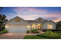 Inviting single-story home showcasing manicured landscaping, a brick driveway, and a two-car garage as dusk settles at 8904 Sw 84Th Cir, Ocala, FL 34481