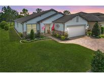 Charming home with a well-manicured lawn, beautiful landscaping, and a brick paver driveway at 9740 Sw 68Th Ln, Ocala, FL 34481