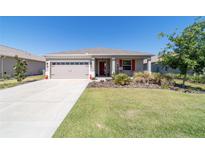 Charming home featuring a well-maintained front yard, two-car garage and a welcoming front porch at 10033 Sw 96Th St, Ocala, FL 34481