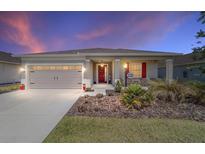 Charming home featuring a well-maintained front yard, two-car garage and a welcoming front porch at 10033 Sw 96Th St, Ocala, FL 34481