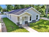 Charming single-story home with a covered entry, featuring stone accents and fresh landscaping at 11415 Nw 15Th St, Ocala, FL 34482