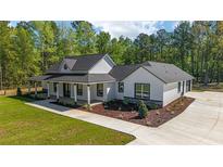 Beautiful new construction home featuring lovely landscaping, a covered porch, and a modern farmhouse aesthetic at 14115 Nw 141St Ave, Williston, FL 32696