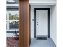 Inviting entryway featuring a white front door, textured walls, and a modern, decorative wood post at 15854 Sw 38 Pl, Ocala, FL 34481