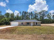 Charming single-story home featuring a neutral color palette, attached garage, and a well-maintained lawn at 22764 Sw Sea Cliff Ave, Dunnellon, FL 34431
