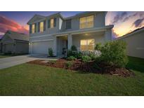 Charming two-story home with a well-manicured lawn and inviting front porch at sunset at 4806 Sw 86Th Ln, Ocala, FL 34476