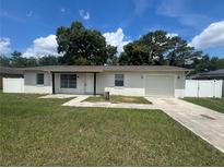 Charming single-story home with a well-maintained lawn, driveway, and white fence at 14646 Sw 43Rd Court Rd, Ocala, FL 34473