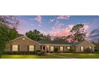 Charming brick home features green shutters, a well-manicured lawn, and inviting curb appeal at 1866 Ne 39Th Ct, Ocala, FL 34470