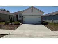 Charming single-story home with neutral siding, stone accents, and a spacious two-car garage at 5077 Stokes Way, Wildwood, FL 34785