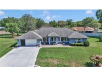 Aerial view of light blue one-story home, with a manicured green lawn and a two car garage at 5350 Sw 82Nd St, Ocala, FL 34476