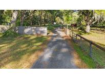Long driveway leading to the property with mature trees and natural landscaping at 6700 Nw 57Th Ave, Ocala, FL 34482