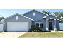 Charming single-story home featuring a well-manicured lawn and a two-car garage at 8004 Juniper Rd, Ocala, FL 34480