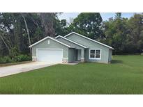 Charming single Gathering home featuring a two car garage, stone accents, and a well manicured lawn at 8661 Juniper Rd, Ocala, FL 34480