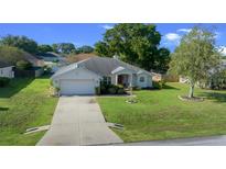 Traditional single-story home featuring an attached garage and well-maintained lawn at 8895 Sw 57Th Court Rd, Ocala, FL 34476