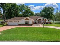 Charming single-story home with well-manicured lawn, mature trees, and inviting curb appeal at 10337 Sw 74Th Ter, Ocala, FL 34476
