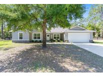 Charming single-story home with stone accents, a two-car garage, and a well-manicured front lawn at 13164 Sw 78Th Place, Dunnellon, FL 34432