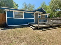 Blue single-story home featuring a wood porch, white trim, and a well-maintained yard at 25292 Ne 132Nd Ln, Fort Mc Coy, FL 32134