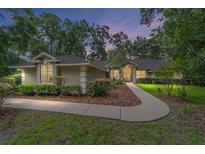 Charming single-story home with manicured lawn and inviting walkway, surrounded by mature trees and lush landscaping at 733 Se 67Th Ln, Ocala, FL 34480