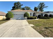 Charming single-story home with a well-maintained lawn, a two-car garage, and manicured landscaping at 7421 Sw 110Th Pl, Ocala, FL 34476
