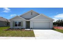 Charming single-story home featuring a two-car garage, well-maintained lawn, and classic architectural details at 15820 Se 101St Cir, Summerfield, FL 34491