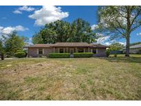 Charming single-story home with well-maintained landscaping, mature trees, and a classic brick facade at 164 Ne 53Rd St, Ocala, FL 34479