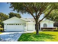 Charming one-story home featuring a three-car garage, well-maintained lawn, and mature landscaping at 1763 Sw 155Th Place Rd, Ocala, FL 34473