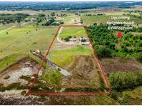 Expansive aerial view of a large lot, highlighting the property's boundaries, nearby wooded areas, and future neighborhood development at 22111 Obrien Rd, Howey In The Hills, FL 34737