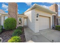 Charming home exterior featuring a brick chimney, well-manicured landscaping, and attached garage at 2343 Se 19Th Cir, Ocala, FL 34471