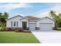 Charming single-story home features a two-car garage and manicured lawn at 3053 Canopy Oak Blvd, Wildwood, FL 34785