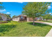 Well-manicured front yard featuring green grass and mature landscaping surrounding the charming single-story home at 3918 Nw 46Th Ter, Ocala, FL 34482