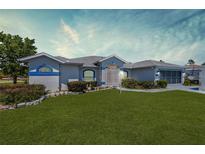 Charming single-story home with manicured lawn and blue trim, offering great curb appeal at 4085 Sw 110Th St, Ocala, FL 34476